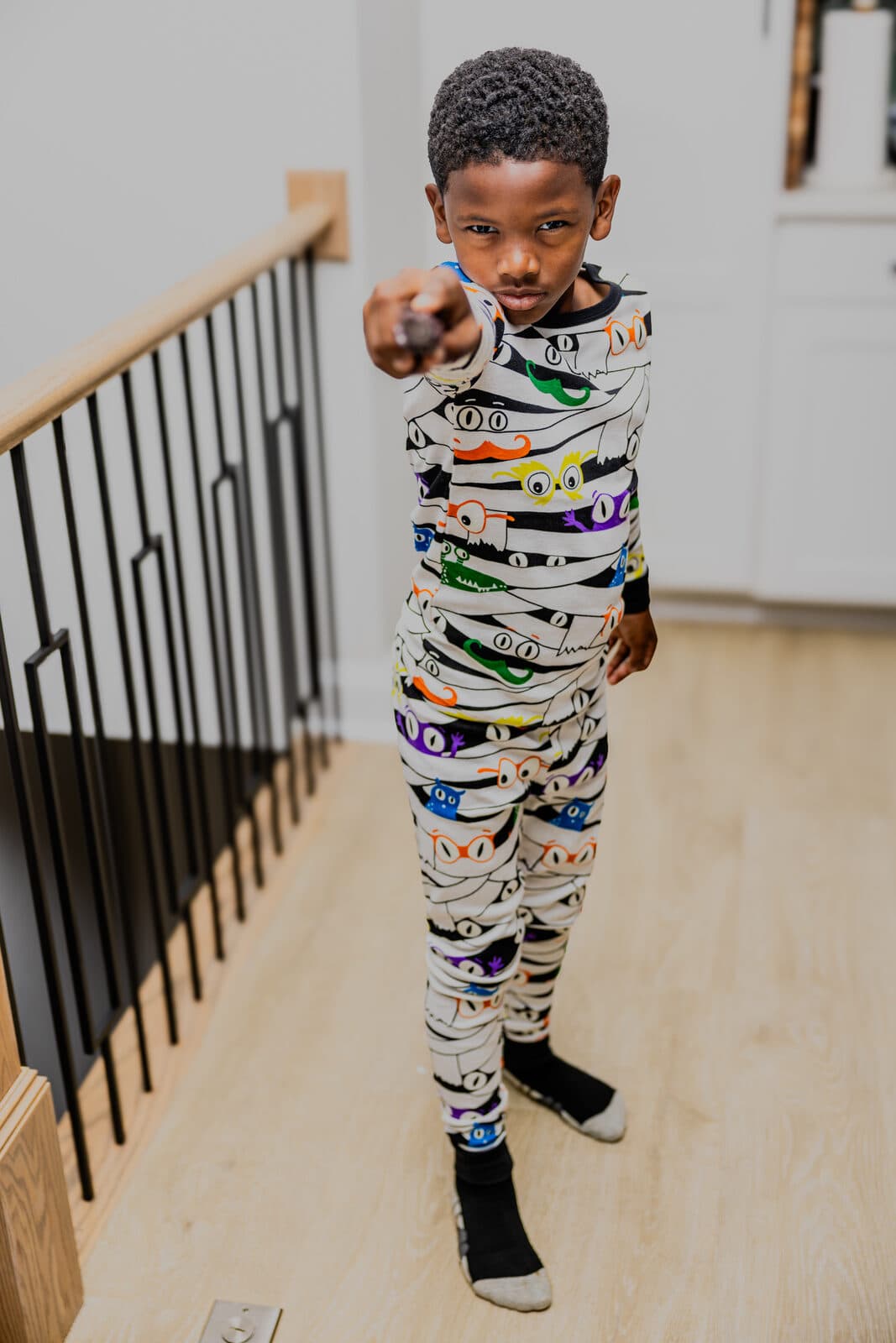 Kid in glow skeleton pajamas on the stairs